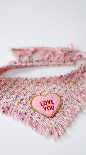 Detal pluszowego serduszka z haftem Love You na tweedowej chuście dla psa Coco